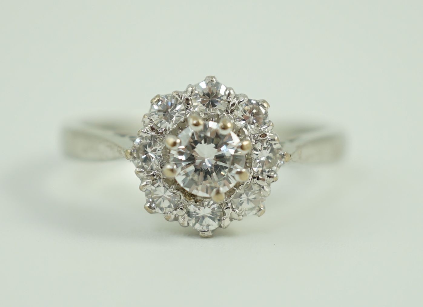 A modern 18ct white gold and nine stone diamond set flower head cluster ring
